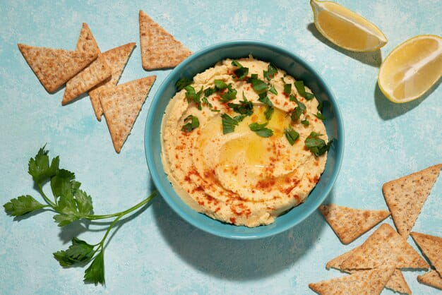 hummus in a blue bowl with coriander.