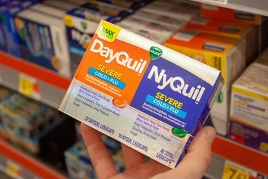 a hand holding DayQuil
