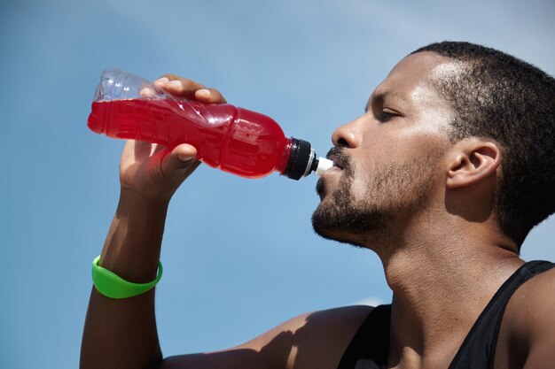 a person drinking gatorade bottle.