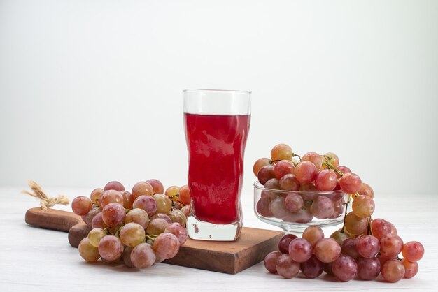 grape juice with grapes placed on a wooden board.