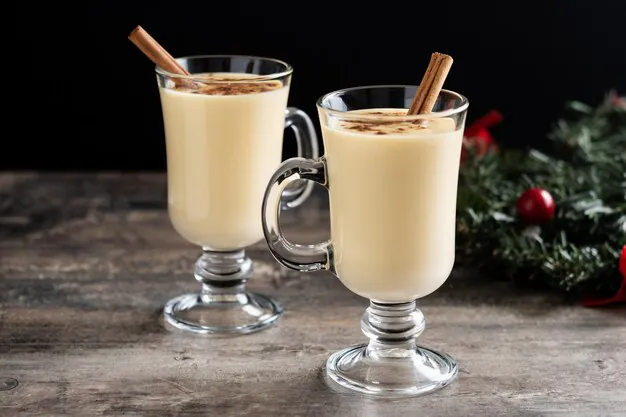 homemade eggnog with cinnamon placed on the wooden table