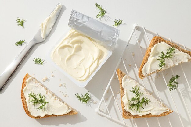 cheese cream in a plastic container with bread slices placed on a grid.