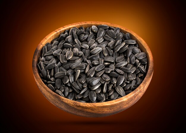 black sunflower seeds in a wooden bowl.
