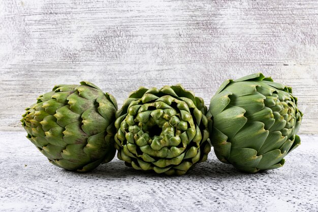 side view of three artichokes placed horizontally