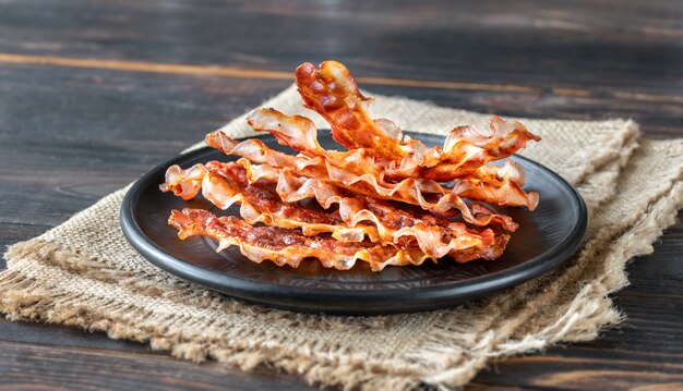 cooked turkey bacons in a black circular plate