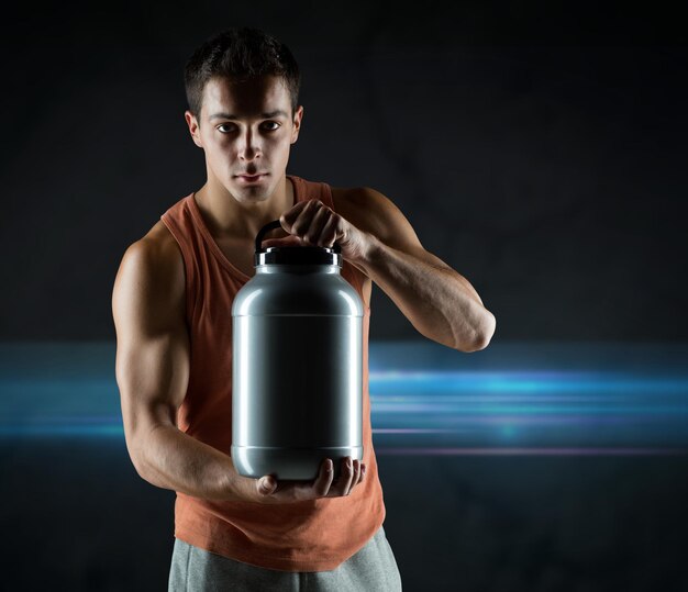 a person holding whey protein bottle.